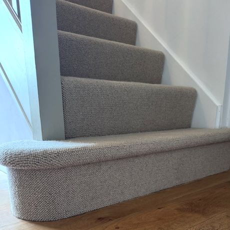 Wool loop carpet fitted round a curved bottom stair